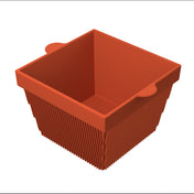 A red, square-shaped silicone basket with vertical ridges on the sides and two rounded tabs for easy gripping, shown empty on a white background. This dishwasher safe bowl features a smooth interior for effortless cleaning.