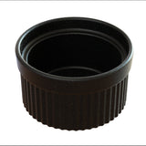 A black, round souffle bowl with a smooth interior and a ridged exterior. This ceramic ramekin is dishwasher safe and shown empty against a white background, with its open top facing upward.