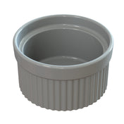A white ceramic souffle bowl with a smooth, glossy finish. The sides feature vertical, evenly-spaced ridges for grip, and the interior is smooth. This ramekin is empty and set against a plain white background.
