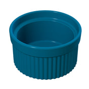 A glossy, deep blue Souffle Bowl with a smooth interior and ribbed exterior stands empty against a white background. The round bowl features thick walls, a slightly flared rim, and is dishwasher safe for easy cleaning.