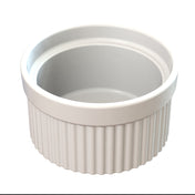 A white ceramic souffle bowl with a smooth interior and ribbed exterior sits on a white background. The round, empty ramekin is shown from a slightly elevated angle, ideal for cold holding desserts or appetizers.