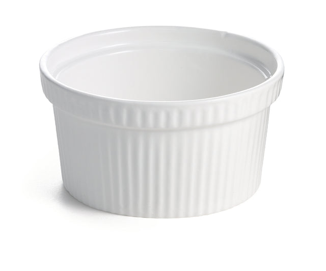 A white ceramic souffle bowl with a smooth interior and vertically ribbed exterior sits on a white surface. This small, round dish has a slightly flared rim and is ideal for baking or serving individual portions of food.