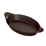 A black, oval-shaped cast iron baking dish with two short, textured handles on opposite sides. The dish features a smooth interior surface and slightly sloped sides, and is dishwasher safe for easy cleaning. Set against a white background.