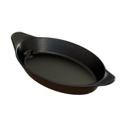 A black, oval-shaped cast aluminum baking dish with two small handles on each end. The dish features a smooth, slightly textured surface with subtle white speckles. It is empty and ideal as a versatile server, shown against a plain white background.