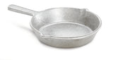 A plain, silver cast aluminum fry pan with a short handle and two small pouring spouts sits on a white background. The skillet's surface is rough and uncoated, and the handle is solid with no grip or hole for hanging.