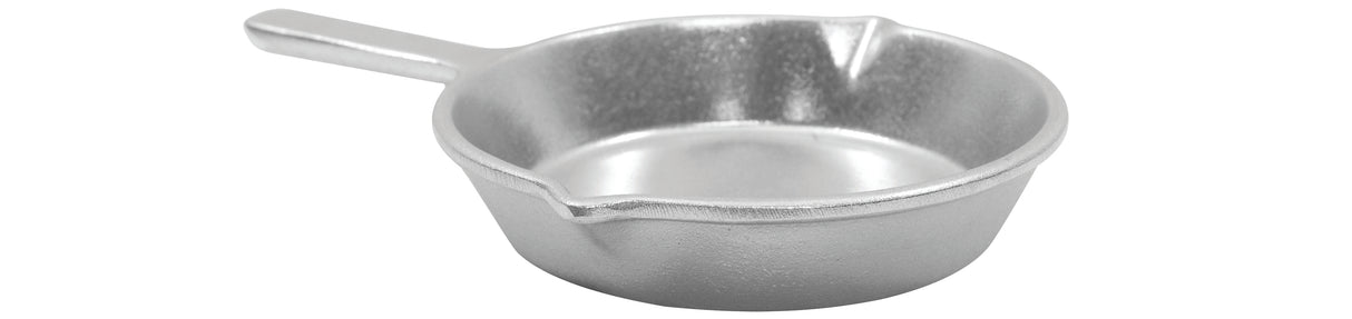 A small, silver-colored cast aluminum skillet with a short handle and two pouring spouts sits on a white background. The fry pan’s rough, matte texture hints at durability and classic style.