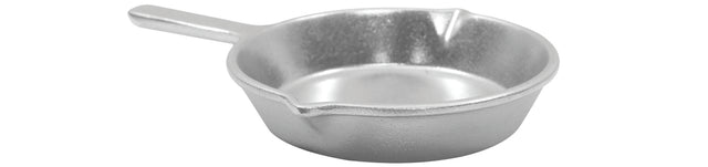 A small, silver-colored cast aluminum skillet with a short handle and two pouring spouts sits on a white background. The fry pan’s rough, matte texture hints at durability and classic style.
