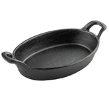 A black, oval-shaped Mini Au Gratin Server made of cast iron with two sturdy handles on either end. Its interior and exterior feature a rough, matte texture typical of cast iron, and the dish sits empty against a plain white background.