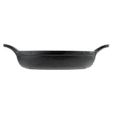 A black TableCraft cast iron baking dish with a textured surface, oval shape, and two curved handles on opposite sides, viewed from the side against a white background; ideal as a mini server for individual portions.