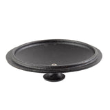 A shallow, round, black cast iron bird bath with a slightly raised rim and smooth surface sits on a short, circular pedestal base. Styled like a mini casserole lid, it resembles classic TableCraft pieces against a white background.
