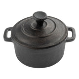A round, black cast iron mini casserole dish with a matching lid and knob handle. The pot, made by TableCraft, has two side handles and a textured, slightly rough surface. The image is taken from above on a white background.