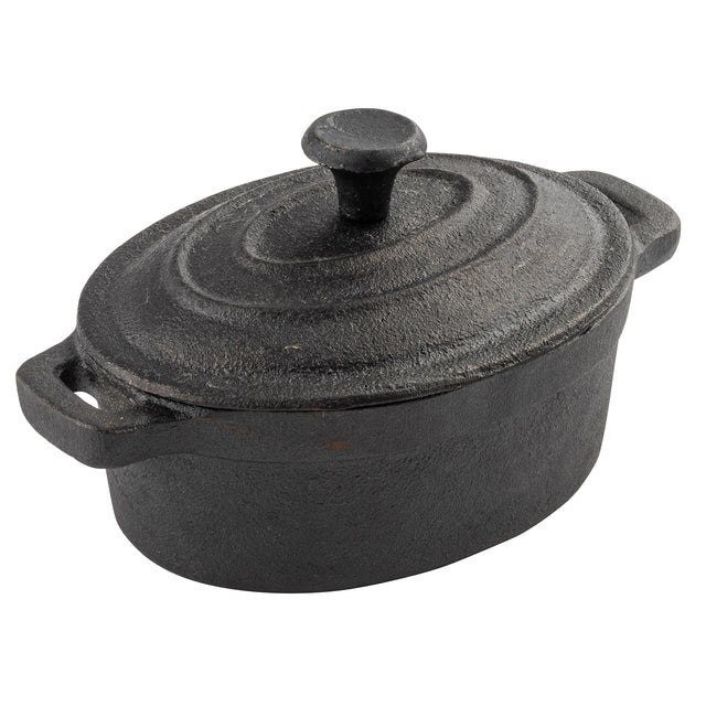 A black cast iron oval Dutch oven by TableCraft with a matching lid and round knob handle. The pot has two side handles, a textured, slightly rough surface showing signs of use, and a lid with concentric circular ridges.