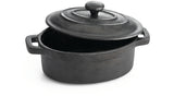 A black cast iron TableCraft dutch oven with two side handles and a matching lid, shown partially open. The textured surface appears matte, and the pot rests on a white background, casting a faint shadow.