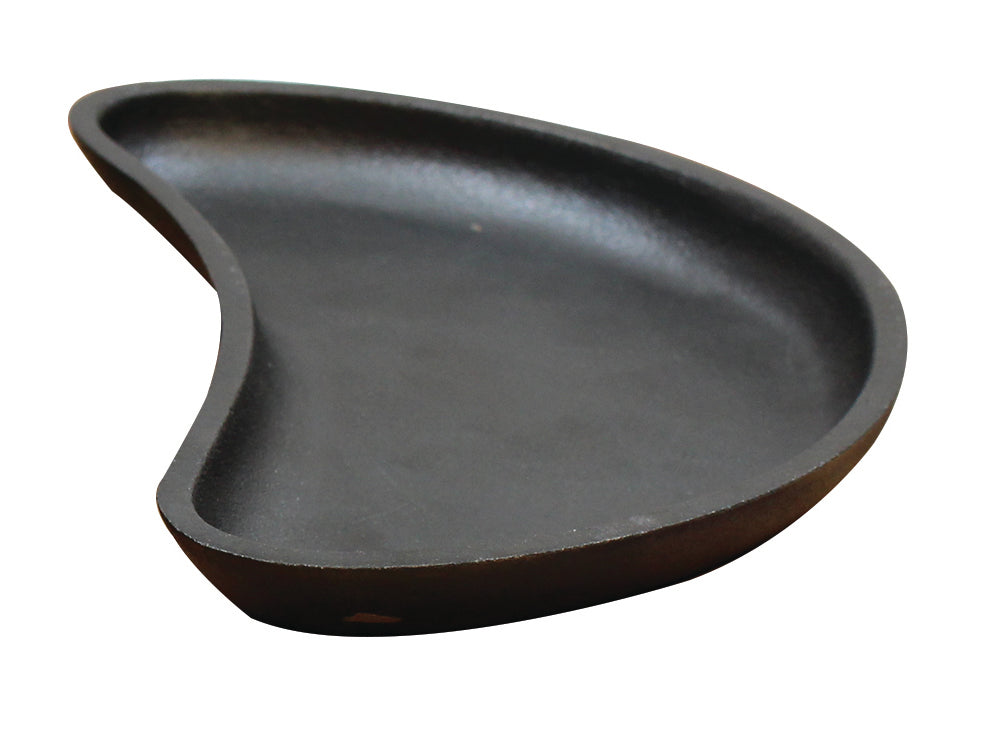 A black, kidney-shaped TableCraft cast iron plate with a shallow, smooth surface and gently curved edges is shown on a white background. Its unique organic form and indented side give this server an asymmetrical, modern appearance.