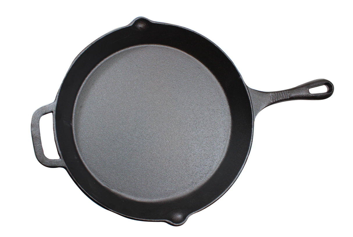 A black pre-seasoned cast iron skillet with a long handle and a small assist handle is shown from above on a white background. The empty skillet features a smooth, matte surface.