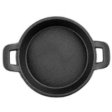 A round, black TableCraft cast iron skillet is shown from above, featuring a textured surface and two rectangular handles. This Mini Server pan is empty and centered on a white background.