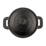 Top view of a round, black TableCraft cast iron mini casserole pot with a lid. The pot features two rectangular handles and a knob on the lid. Its textured, slightly worn surface is set against a white background.