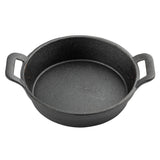 A round, black cast iron skillet from TableCraft with a rough texture and two flat handles sits empty against a plain white background—perfect as a fajita platter for serving sizzling dishes straight to the table.
