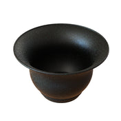 A wide, black Tulip Salad Bowl with a flared rim and speckled texture. Its matte surface features white and green flecks for a starry look. The cast aluminum salad bowl has a round shape, narrow base, and open, curved sides.