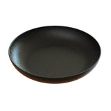 A round, shallow, black ceramic pasta bowl with a subtly textured surface and a slight rim, shown against a white background. The plate has a matte finish and a minimalist, modern design.