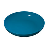 A simple, round, deep blue cast aluminum pasta bowl with a smooth, glossy surface is shown against a plain white background. The bowl is empty, and a white highlight reflects off its rim, emphasizing its shiny finish.