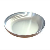A shiny, empty cast aluminum pasta bowl with smooth, rounded edges sits on a plain white background. The surface displays subtle highlights and reflections, emphasizing its metallic texture and clean, dishwasher safe appearance.
