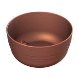 A round, metallic copper bowl with a matte copper finish sits on a white background. Crafted from cast aluminum, the bowl features horizontal grooves near the base and a smooth inner indentation, reflecting soft light and highlighting its texture.