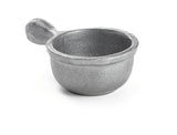 A small, round, silver-colored metal scoop with a short, thick handle. Crafted from cast aluminum with a rough, textured finish, it sits on a white background, casting a faint shadow beneath it. Dishwasher safe for easy cleaning.