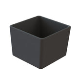 A matte black, square-shaped cold holding bowl with rounded edges. Crafted from cast aluminum, its minimalist design features smooth, spacious surfaces. The container is dishwasher safe and shown against a plain white background.