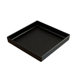 A black, square tray made from Duracoat coated cast aluminum with a slightly raised edge and smooth, matte surface featuring tiny white speckles. The tray is dishwasher safe and set empty against a plain white background.