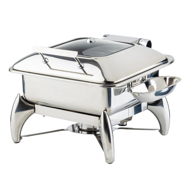 A shiny stainless steel chafing dish with a clear, hinged lid, elevated on four curved legs. A small replacement spoon rest is attached to one side, and a fuel holder beneath the dish keeps food warm for serving.