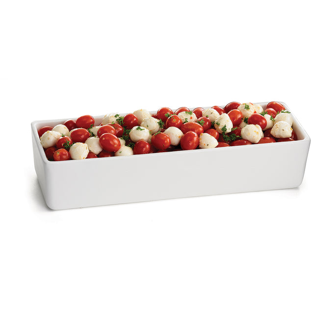 A rectangular white ceramic dish, perfect for cold holding, is filled with a salad of small mozzarella balls, halved cherry tomatoes, and fresh herbs, set against a plain white background.
