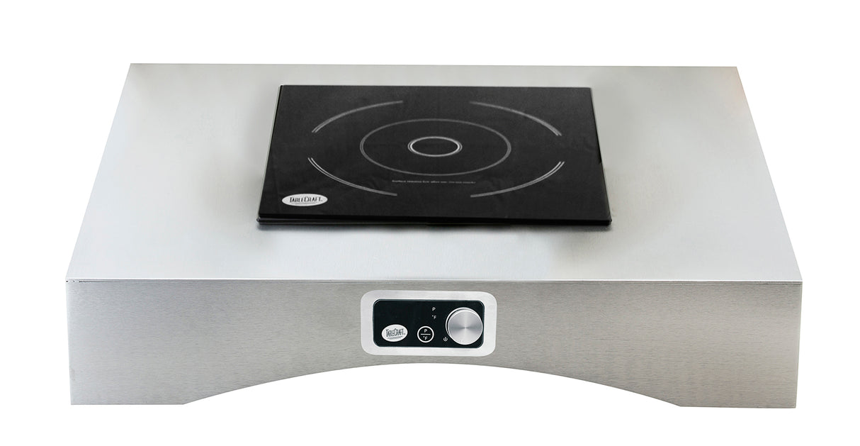 A stainless steel TableCraft Products countertop induction cooktop features a single black induction burner with circular heating zone markings. The front panel includes a control knob and buttons for adjusting settings. The background is plain white.