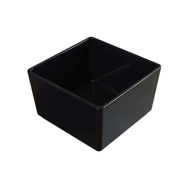 A black, square-shaped cast aluminum bowl with smooth, glossy sides and sharp edges is viewed from above, revealing its deep interior and slightly reflective surface. The bowl appears empty and is set against a white background.