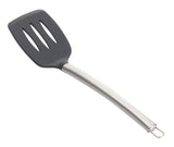 A serving spatula with a curved stainless steel handle and a black, slotted, rectangular head. Three elongated slots are in the head, and a small metal loop at the handle’s end allows for easy hanging. Shown on a white background.