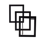 Three black, empty rectangular frames are arranged in a staggered, overlapping pattern like a minimalist steel stand. The upright frames create depth as they rest against a plain white background, each one partially inside the next.