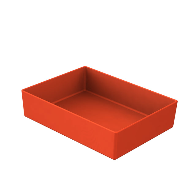 A plain, rectangular, open-top cast aluminum bowl is shown. It is solid orange in color with straight sides and sharp corners. The box sits on a white background, angled to reveal its interior and three sides. There are no markings or decorations.