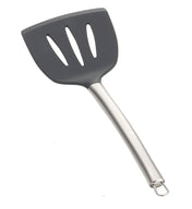 A slotted serving spatula with a black, wide, silicone head featuring three elongated holes and a curved stainless steel handle ending in a metal hanging loop. The spatula is set against a plain white background.