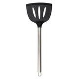 A black serving spatula with a wide, silicone head featuring three vertical slots and a long stainless steel handle with a loop for hanging, shown against a white background.