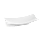 A modern, rectangular white ceramic plate with slightly raised, curved edges and a smooth surface, resting on a small rectangular base—ideal for pairing with a Sierra Collection Bowl or cast aluminum bowl. The plate is empty and set against a plain white background.