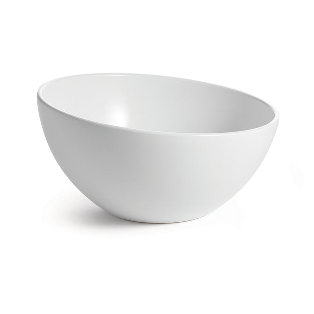 A white, round Sierra Collection Bowl with smooth, clean lines sits on a white surface. The bowl is empty and angled slightly to the left, casting a faint shadow on the right. A plain, bright background emphasizes the bowl’s shape and simplicity.