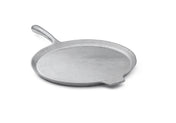 A flat, round, silver cast aluminum pizza pan with a slightly raised edge, a long curved handle on one side, and a small helper tab on the opposite side. The smooth surface appears against a plain white background.