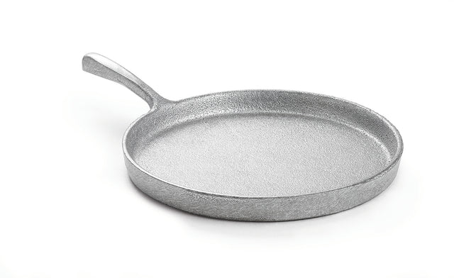 A round, silver metallic frying pan made from cast aluminum with a textured surface and a single handle, photographed on a white background. The pan is empty and slightly angled, showing its depth and sturdy construction.