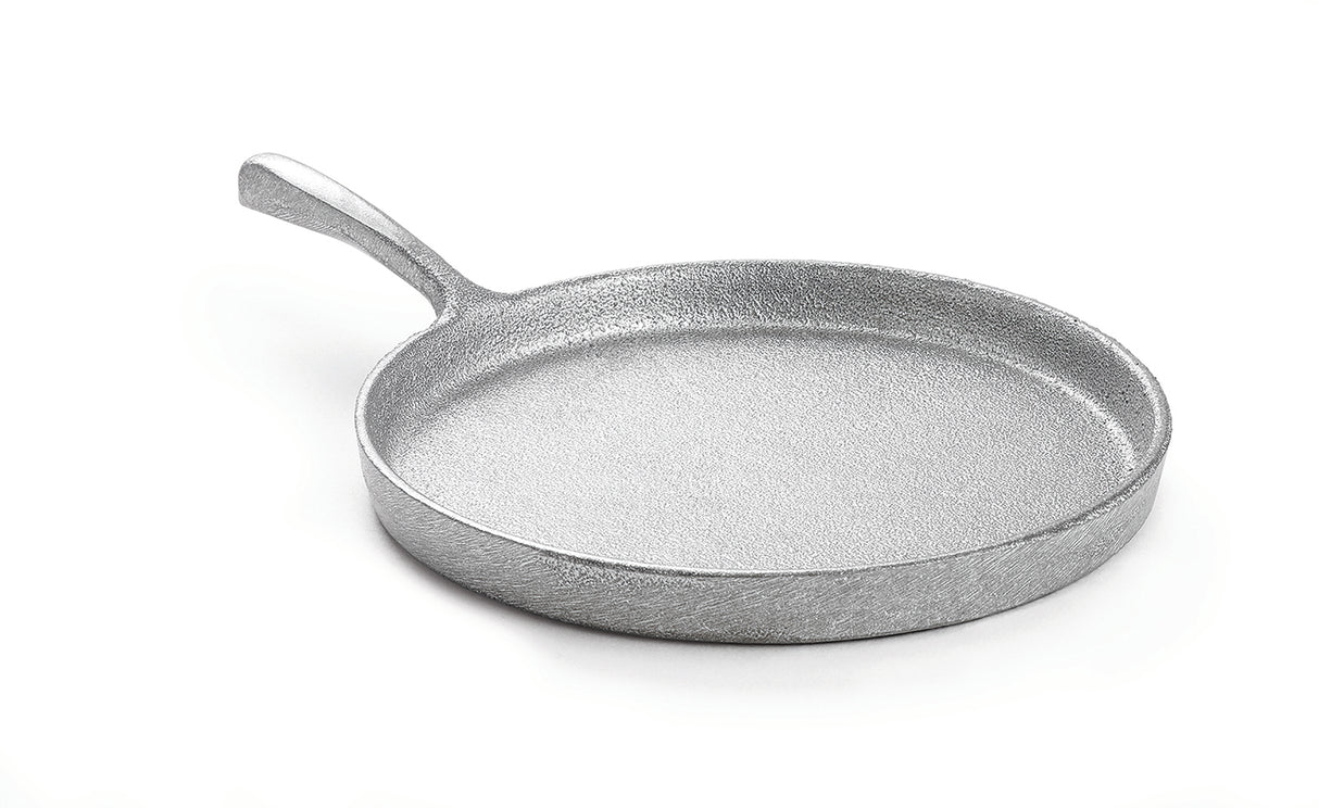 A silver, textured, round cast aluminum frying pan with a single curved handle is shown on a white background. The pan has high sides and a rough, matte surface. The handle extends smoothly from one side of the pan.