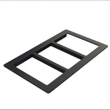 A black, rectangular, three-gang wall plate with three open slots, made from Duracoat coated cast aluminum for durability. Viewed at an angle against a white background, it’s designed to cover and organize three wall switches or outlets.