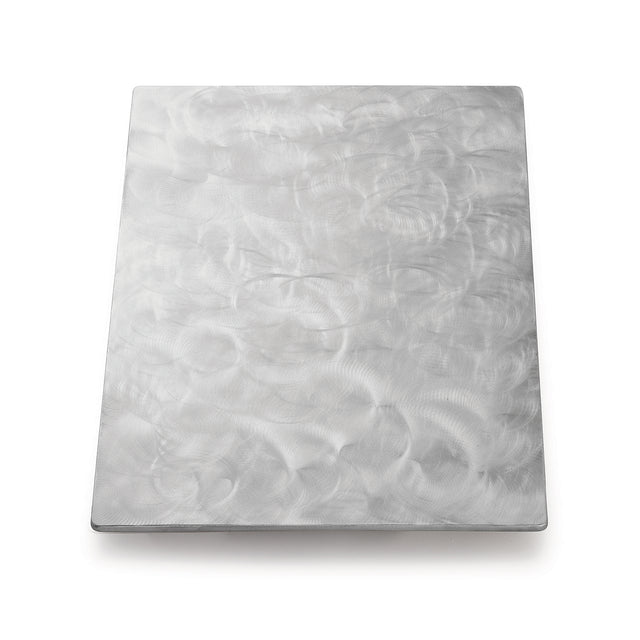 A rectangular sheet of brushed stainless steel with a matte finish. Swirling, circular patterns are etched into the metal, creating a textured appearance. The plain white background highlights its reflective quality—plus, it’s dishwasher safe.