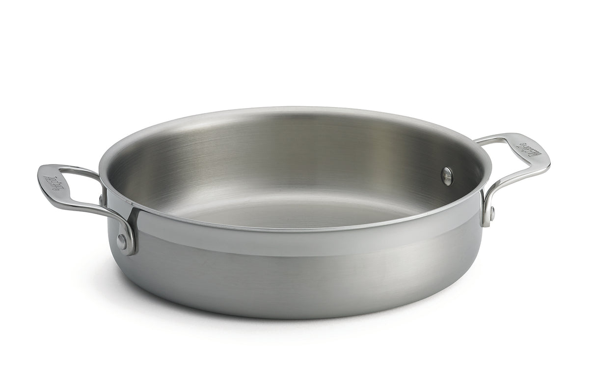 A tri-ply stainless steel Brazier Pan with two sturdy handles, one on each side. Its wide, flat base and high sides offer even heating, while the smooth, reflective surface is induction safe. The pan is shown without a lid against a plain white background.