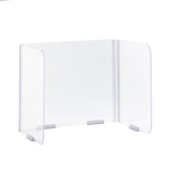 A clear acrylic Desk Safety Shield with three panels features folding hinges at the corners; the wide center panel and two angled side panels are joined securely, while metal brackets fasten the base to a white surface.