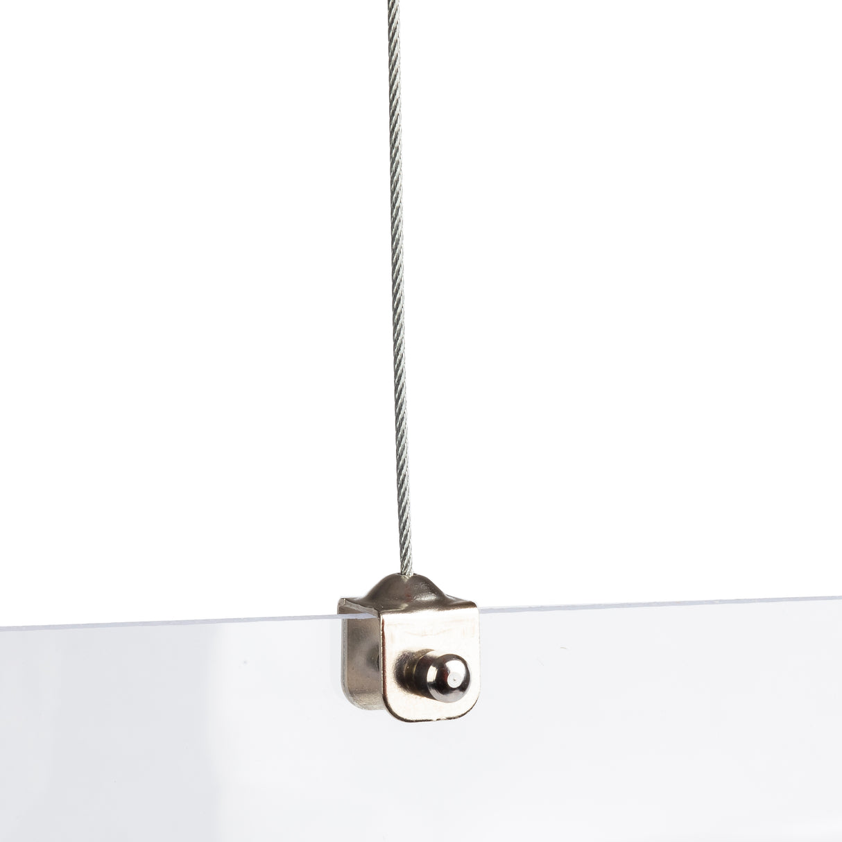 A close-up of a metal cable attached to an acrylic panel using a small, silver clamp. The cable hangs vertically from above, securing the top edge of the clear Hanging Safety Shield against a white background.