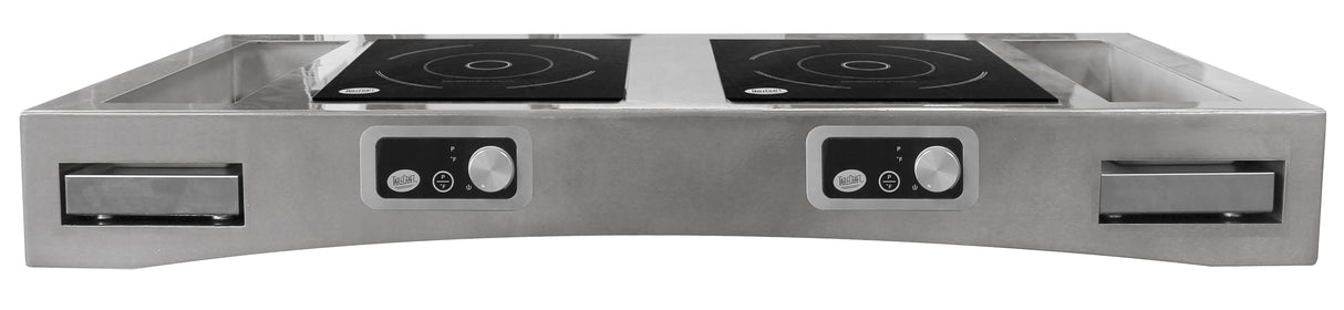 A stainless steel Double Induction Countertop Station is seen from the front, featuring two black induction cooktops with circular patterns, control panels with dials and buttons, and pull-out drawers or trays on either side against a plain white background.